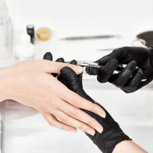 professional-manicurist-black-gloves-provides-service-client-making-manicure-with-manicure-cuticle-trimmer